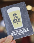 ATX Ale Trail passport held by a hand with a blurred background