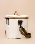 White cooler bag with brown handles and straps on a beige background