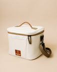 White cooler bag with brown handles and a visible brand label on a beige background
