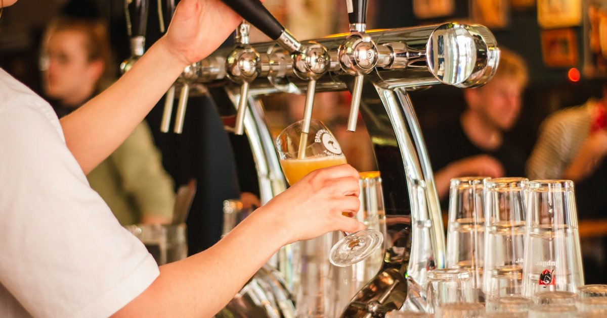 Bartender pouring a craft beer on tap at an Austin brewery