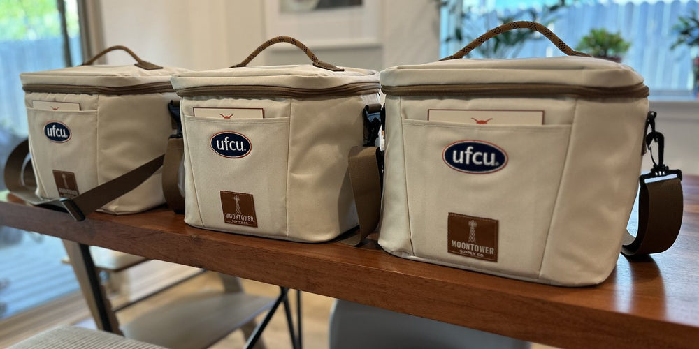 Three co-branded UFCU and Moontower coolers lined up